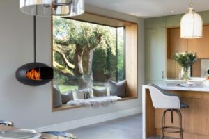 Contemporary Green and Stained Oak kitchen with picture window and bio fuel cocoon hanging fireplace